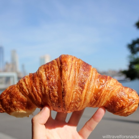 Almondine Bakery croissant with the NYC skyline